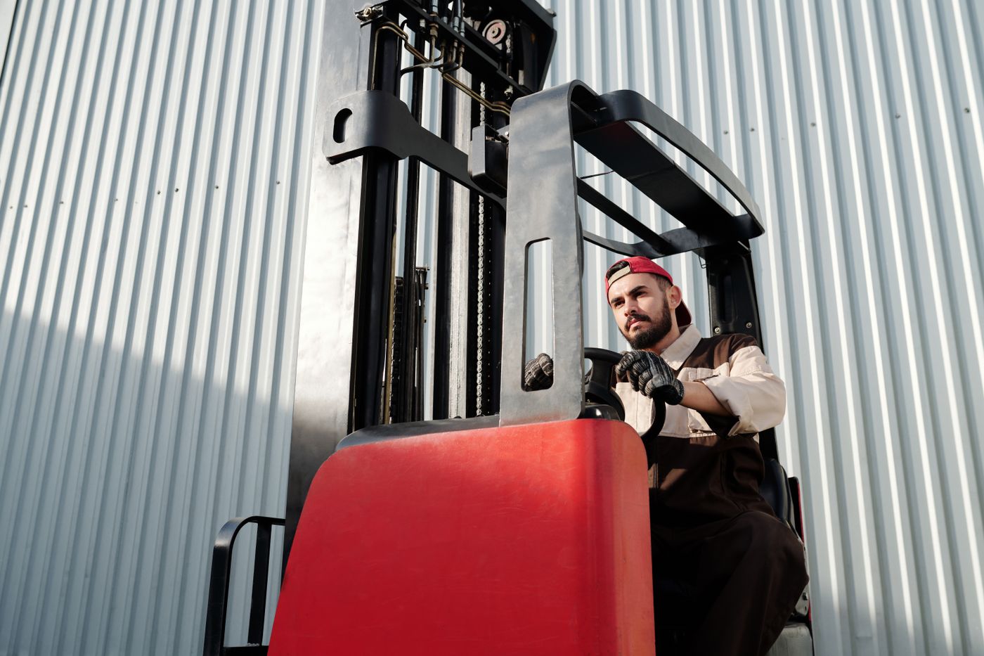 Forklift operator beside a warehouse building